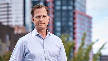 Curt Bailey, a man standing in front of a city.
