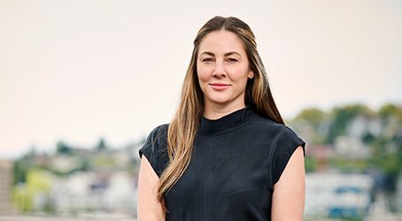 Jill Thomas, a woman in a black top standing in front of a city showcasing Bloodworks Bio.